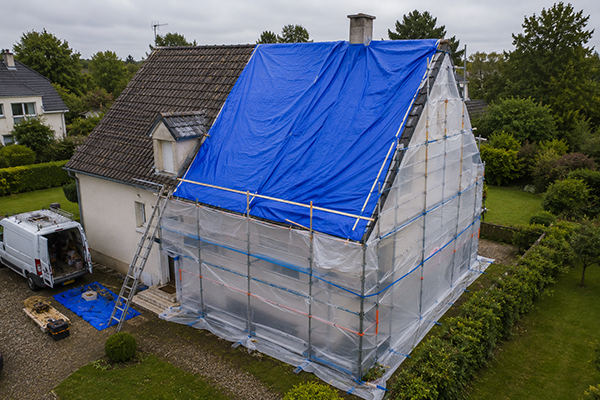Pose d'une bâche toiture et protection de façade en Bourgogne-Franche-Comté après des intempéries afin de limiter les infiltrations d'eau et sécuriser l'habitation avant les réparations définitives.